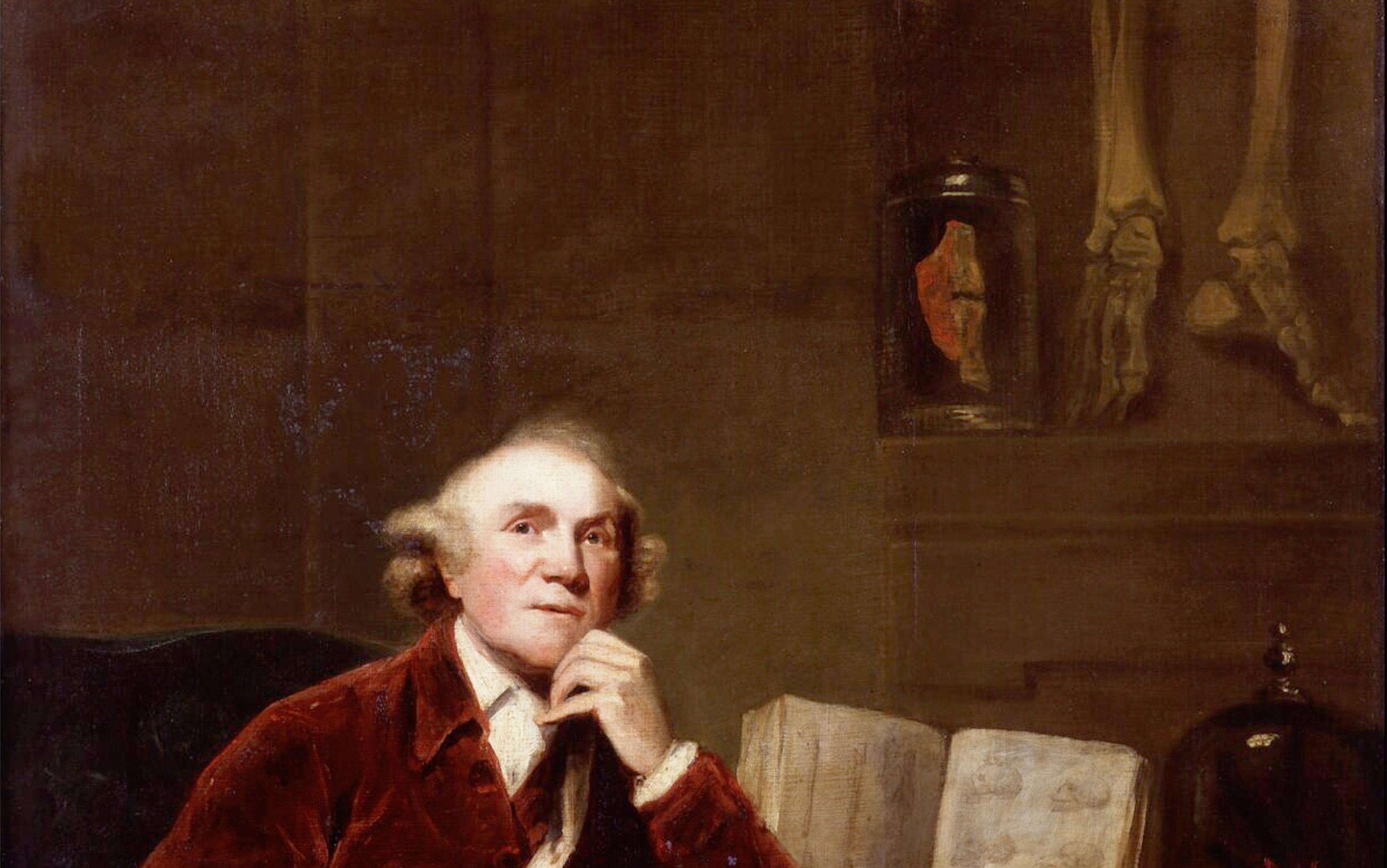 Portrait of a man in a red coat, seated, with his chin resting on his hand, an open book, and anatomical specimens in jars and bones in the background.